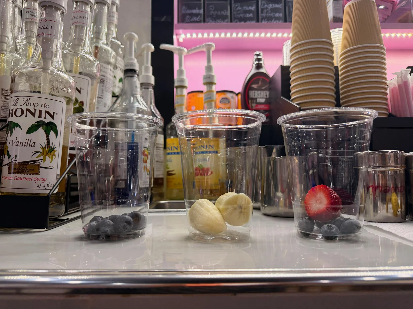 Fresh blueberries, banana and strawberry at the base of empty cups behind the counter at Café Mia