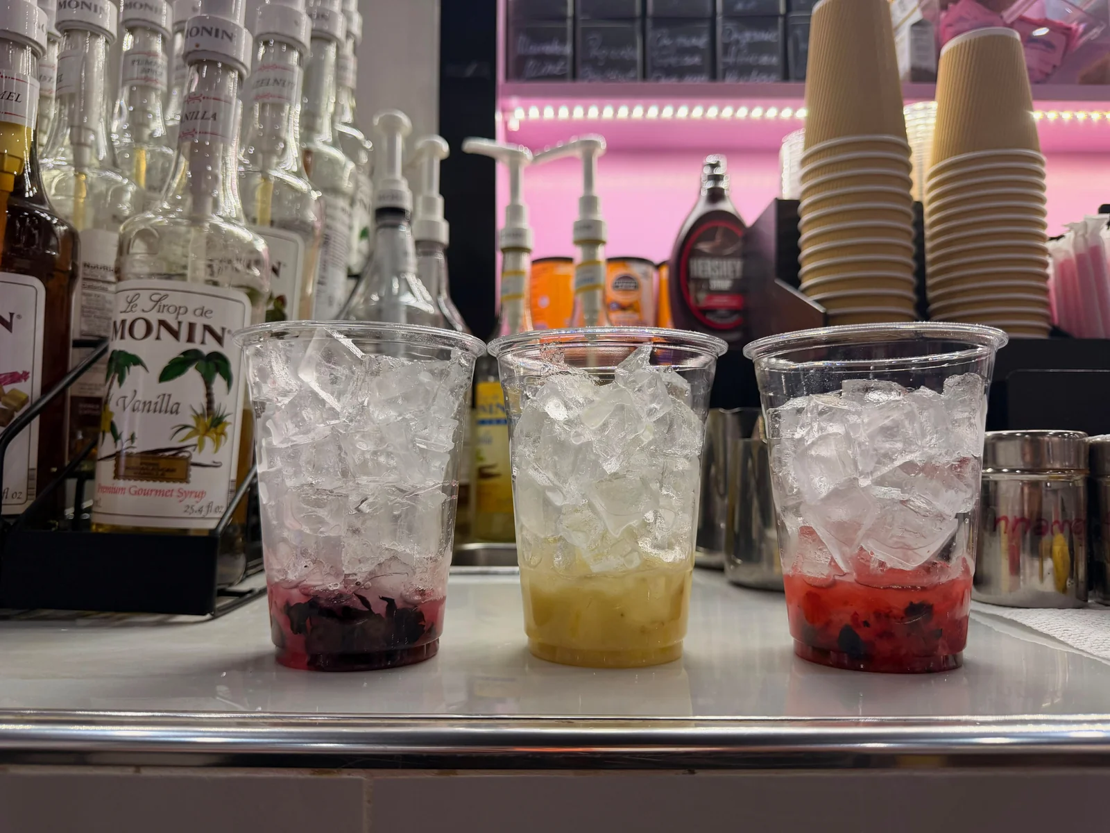 Blended fruit purée at the bottom of each cup with large ice cubes on top