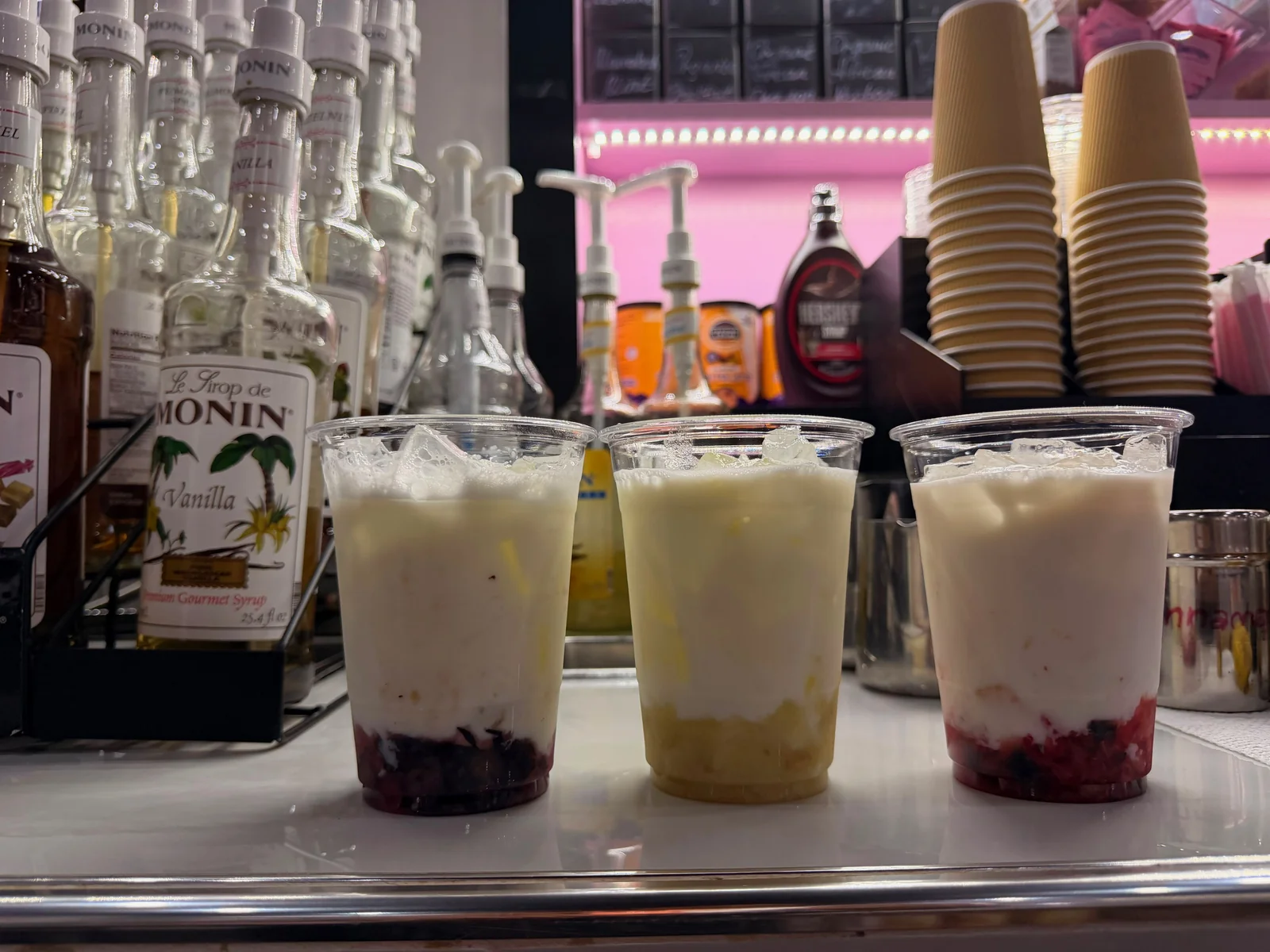 Cold oat milk poured over the fruit purée and ice, forming a middle layer